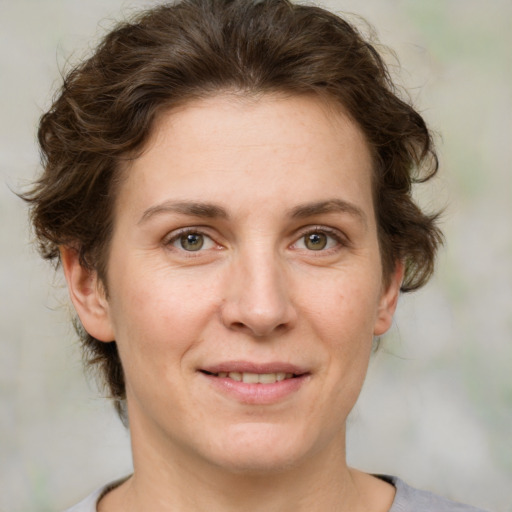 Joyful white adult female with medium  brown hair and green eyes