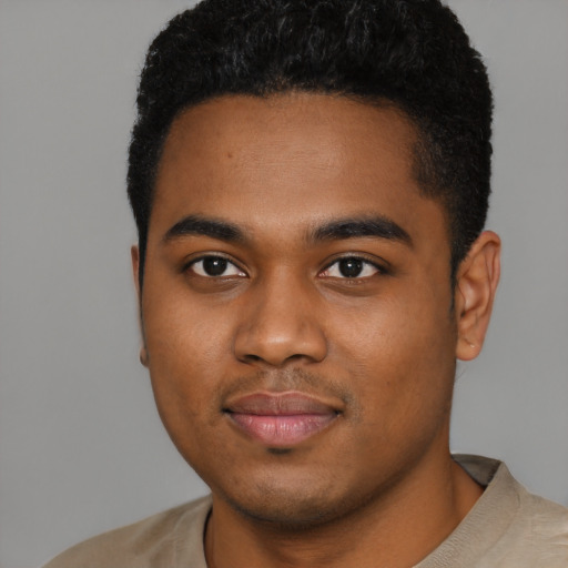 Joyful black young-adult male with short  brown hair and brown eyes