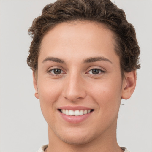 Joyful white young-adult female with short  brown hair and grey eyes