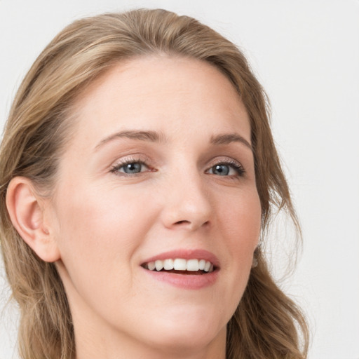 Joyful white young-adult female with long  brown hair and blue eyes