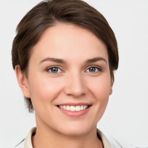 Joyful white young-adult female with short  brown hair and grey eyes