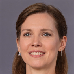 Joyful white adult female with long  brown hair and grey eyes