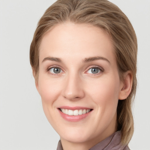 Joyful white young-adult female with long  brown hair and blue eyes