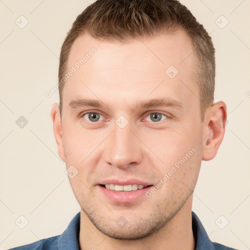 Joyful white young-adult male with short  brown hair and grey eyes