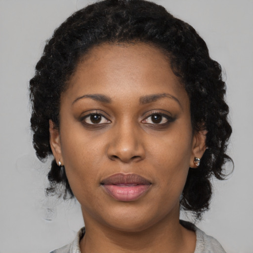 Joyful black young-adult female with medium  black hair and brown eyes