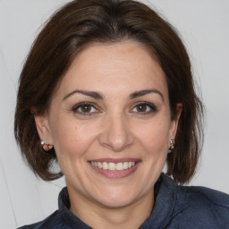 Joyful white adult female with medium  brown hair and brown eyes