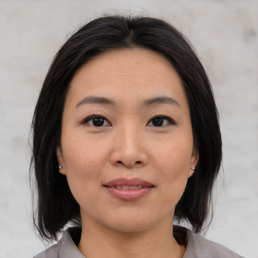 Joyful asian young-adult female with medium  black hair and brown eyes