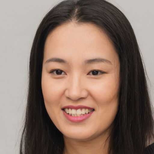 Joyful asian young-adult female with long  brown hair and brown eyes