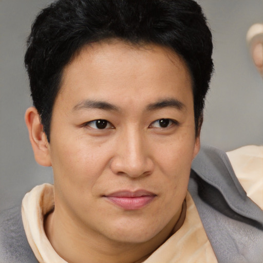 Joyful asian young-adult male with short  brown hair and brown eyes