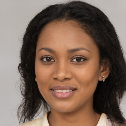 Joyful black young-adult female with long  brown hair and brown eyes