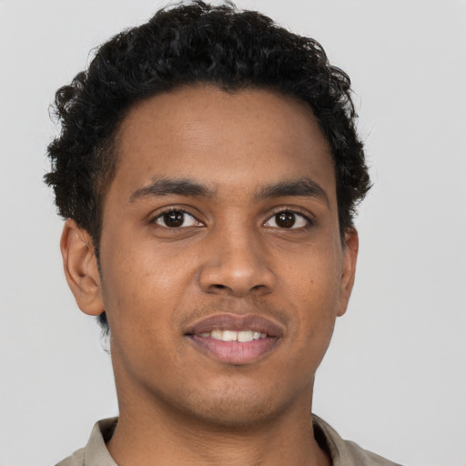 Joyful black young-adult male with short  brown hair and brown eyes