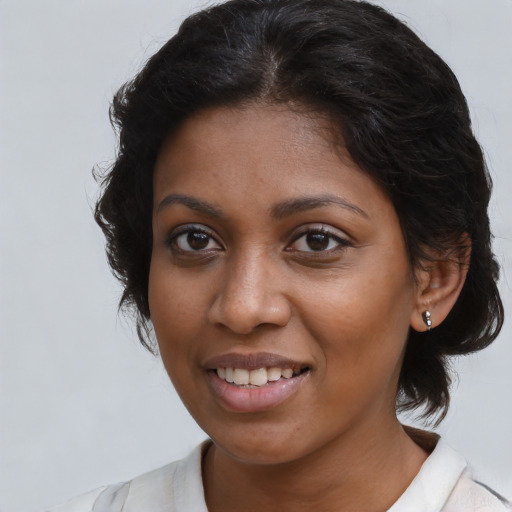 Joyful black young-adult female with medium  brown hair and brown eyes