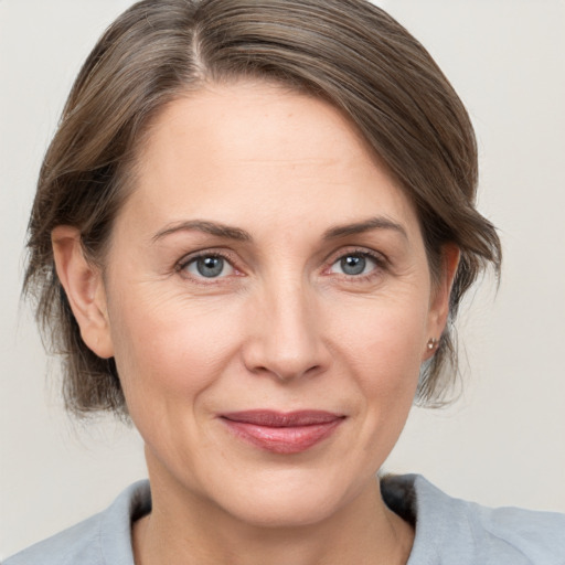 Joyful white adult female with medium  brown hair and grey eyes