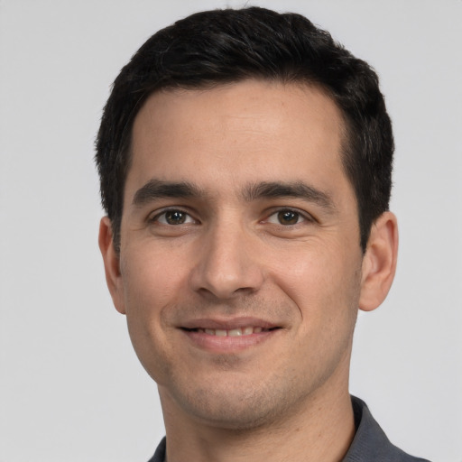 Joyful white young-adult male with short  black hair and brown eyes