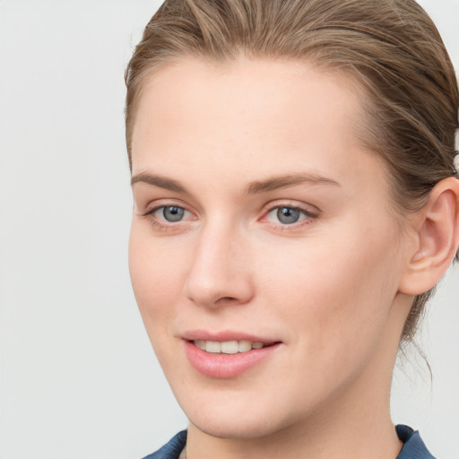 Joyful white young-adult female with short  brown hair and blue eyes