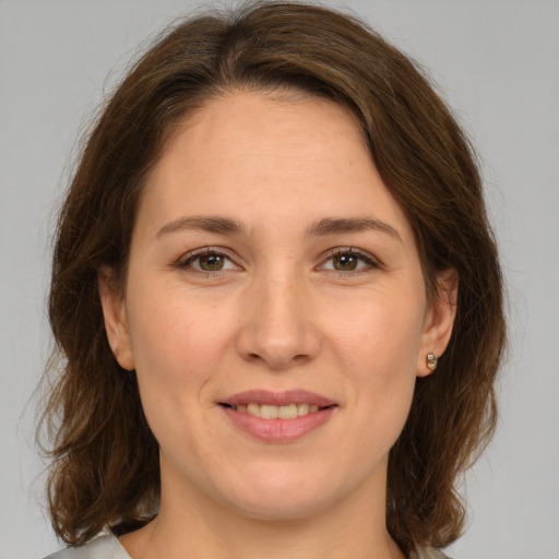 Joyful white young-adult female with medium  brown hair and green eyes