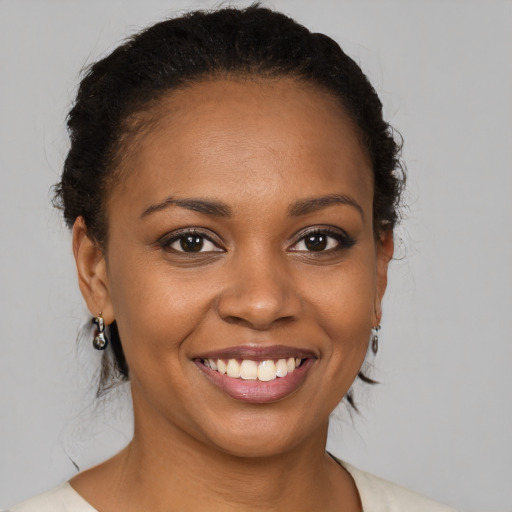 Joyful black young-adult female with medium  brown hair and brown eyes