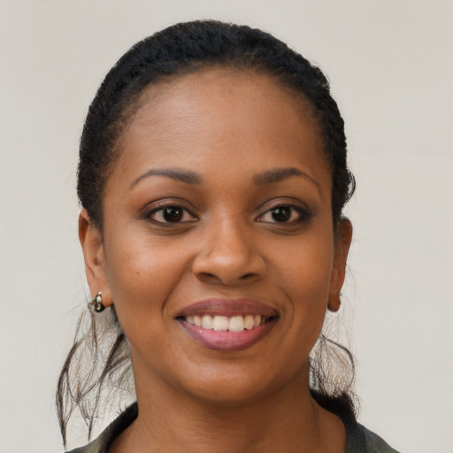 Joyful black young-adult female with short  black hair and brown eyes
