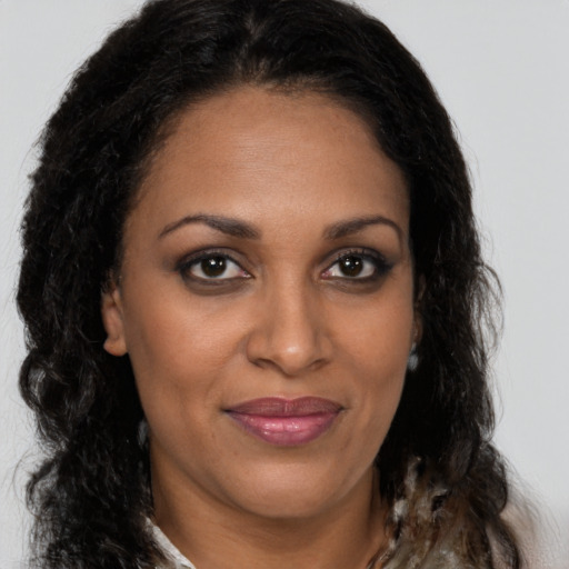 Joyful black adult female with long  brown hair and brown eyes