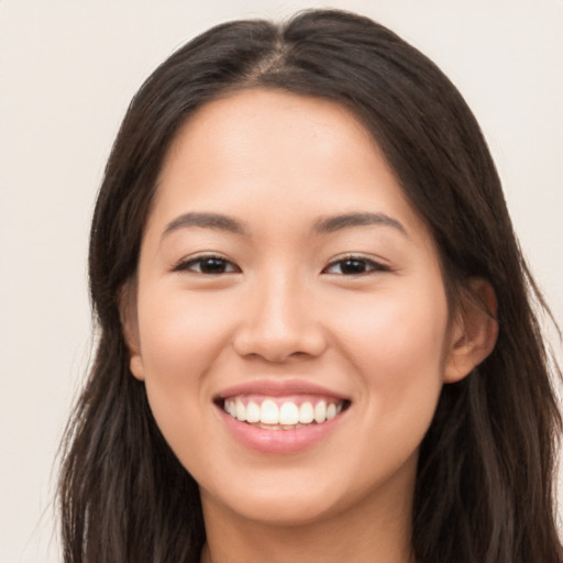 Joyful latino young-adult female with long  brown hair and brown eyes