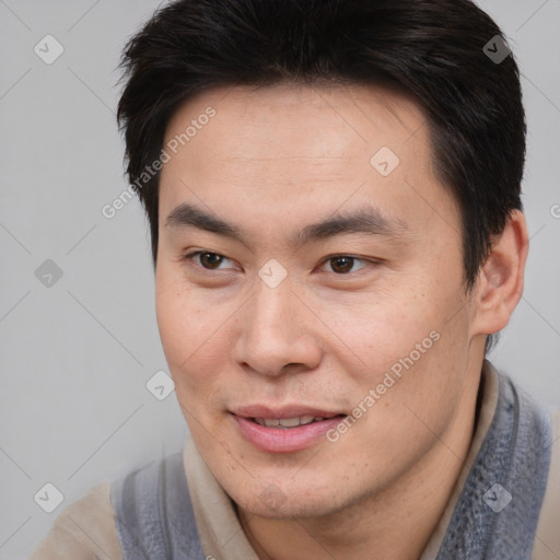 Joyful asian young-adult male with short  brown hair and brown eyes