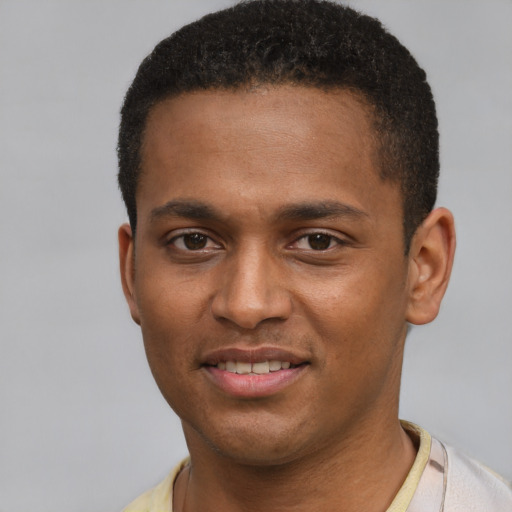 Joyful black young-adult male with short  brown hair and brown eyes