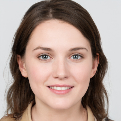 Joyful white young-adult female with medium  brown hair and grey eyes