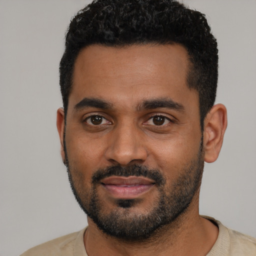 Joyful black young-adult male with short  black hair and brown eyes