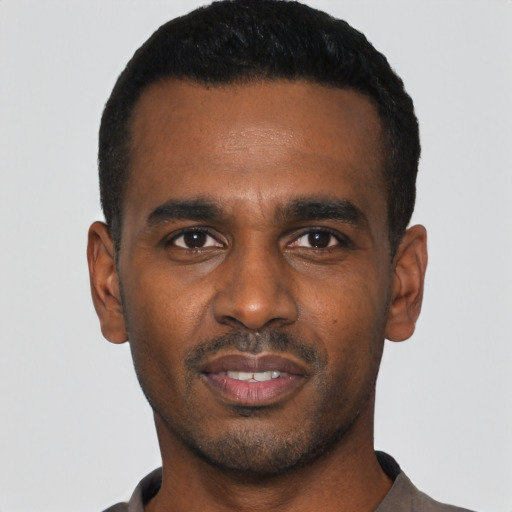 Joyful black young-adult male with short  black hair and brown eyes