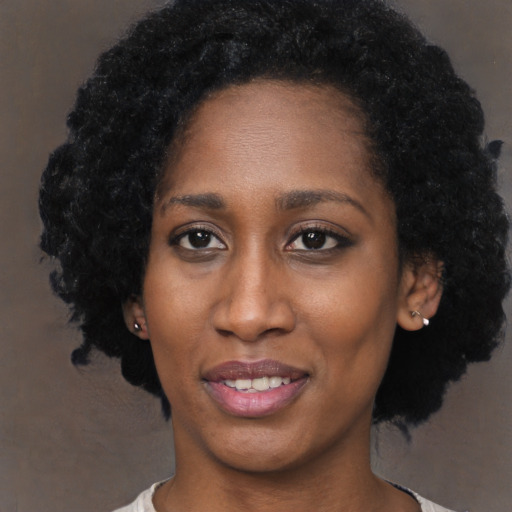 Joyful black young-adult female with short  black hair and brown eyes