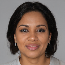 Joyful black adult female with medium  brown hair and brown eyes