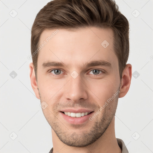 Joyful white young-adult male with short  brown hair and grey eyes