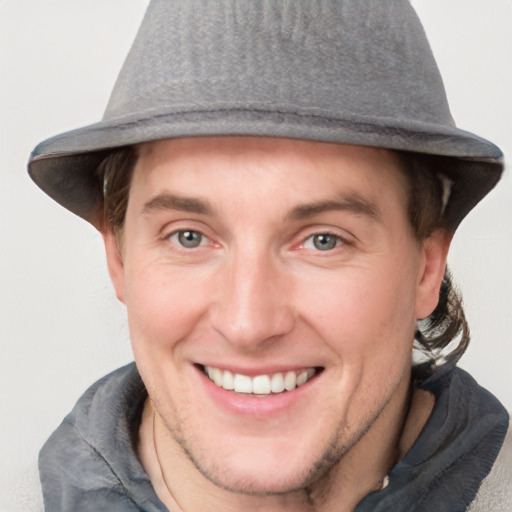 Joyful white young-adult male with short  brown hair and grey eyes