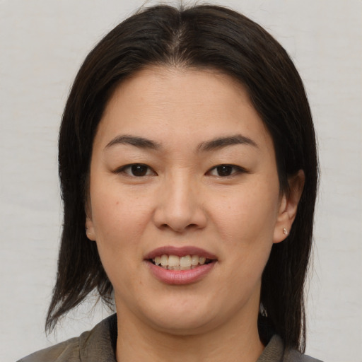 Joyful asian young-adult female with medium  brown hair and brown eyes