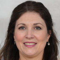 Joyful white adult female with long  brown hair and brown eyes