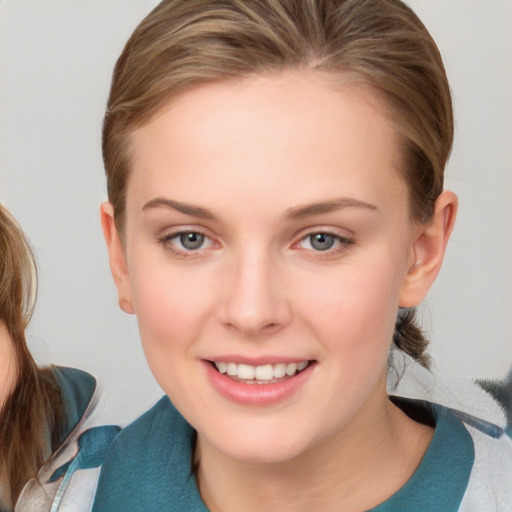 Joyful white young-adult female with medium  brown hair and grey eyes