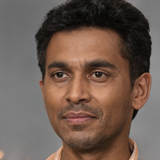 Joyful latino adult male with short  black hair and brown eyes