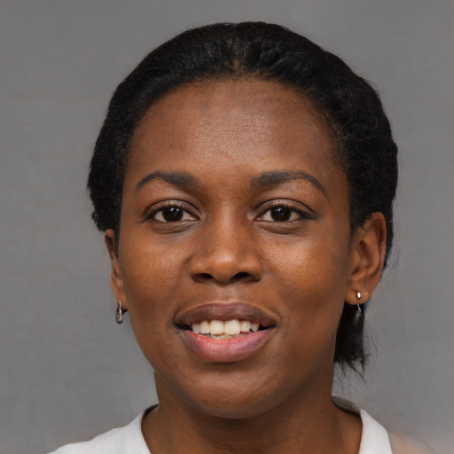 Joyful black young-adult female with short  black hair and brown eyes