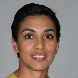 Joyful latino young-adult female with short  brown hair and brown eyes