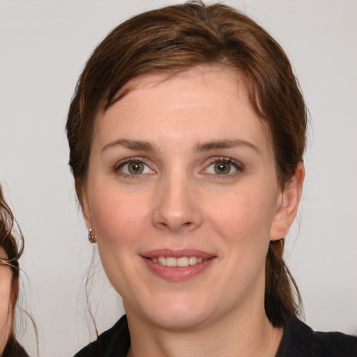 Joyful white young-adult female with medium  brown hair and grey eyes