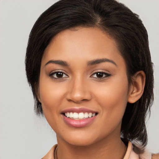 Joyful latino young-adult female with medium  brown hair and brown eyes