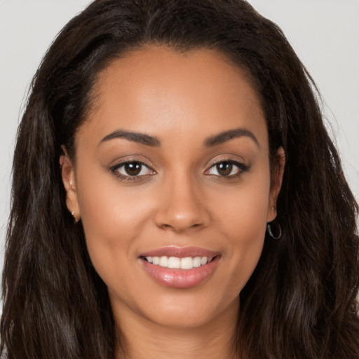 Joyful latino young-adult female with long  brown hair and brown eyes