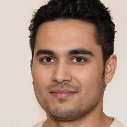 Joyful latino young-adult male with short  black hair and brown eyes