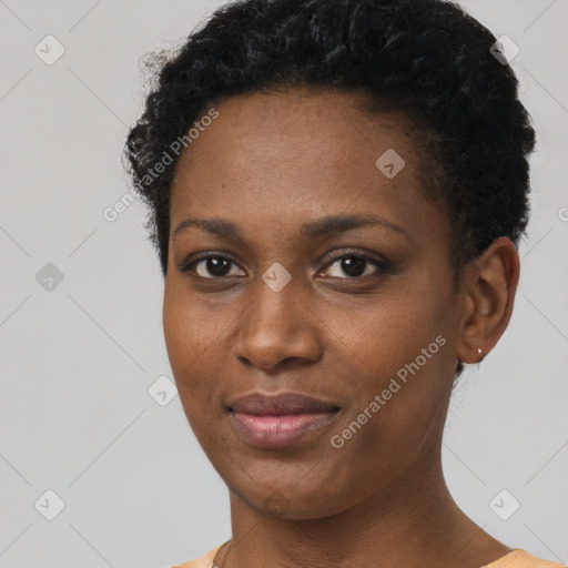 Joyful black young-adult female with short  black hair and brown eyes