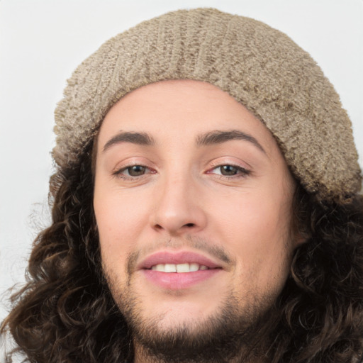 Joyful white young-adult male with long  brown hair and brown eyes