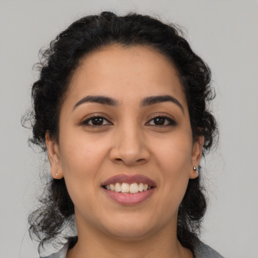 Joyful latino young-adult female with long  brown hair and brown eyes