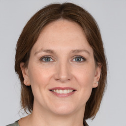 Joyful white adult female with medium  brown hair and grey eyes