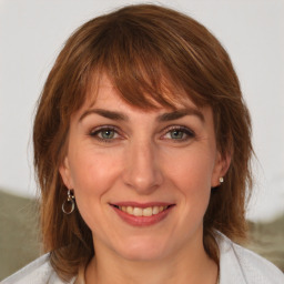 Joyful white adult female with medium  brown hair and green eyes