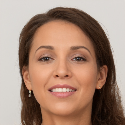 Joyful white young-adult female with long  brown hair and brown eyes