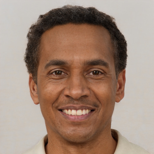 Joyful latino adult male with short  brown hair and brown eyes